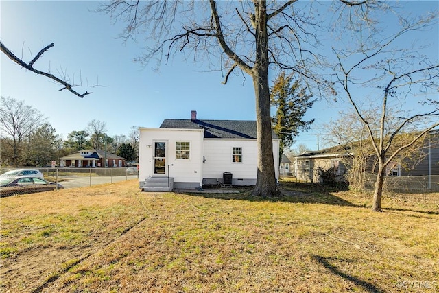 back of house with a lawn and central air condition unit