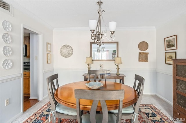 carpeted dining area featuring ornamental molding and a notable chandelier