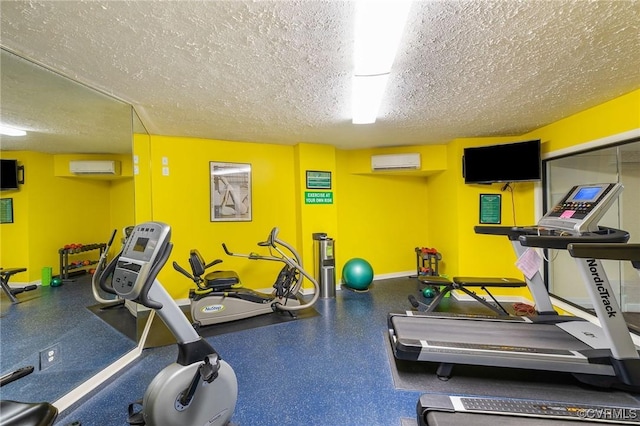 gym featuring a wall unit AC and a textured ceiling