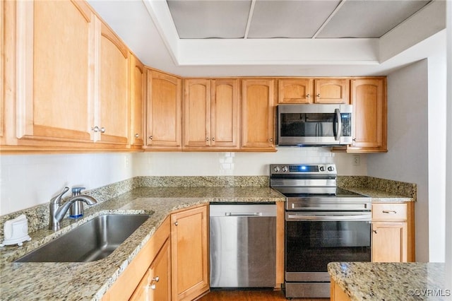 kitchen featuring light stone counters, sink, stainless steel appliances, and light brown cabinets