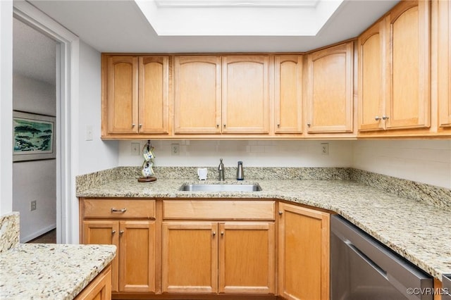 kitchen featuring light stone counters, stainless steel dishwasher, light brown cabinetry, and sink