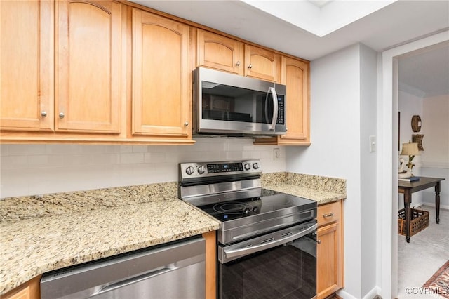 kitchen featuring tasteful backsplash, light brown cabinetry, light stone counters, and appliances with stainless steel finishes