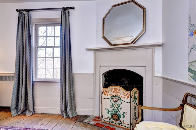 interior details with hardwood / wood-style flooring and radiator