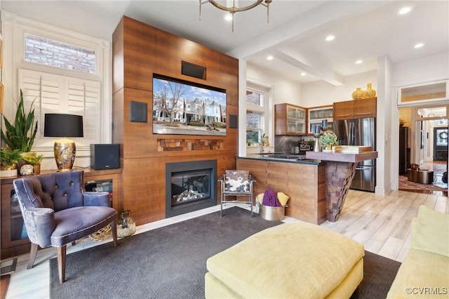 living room featuring beam ceiling and light wood-type flooring