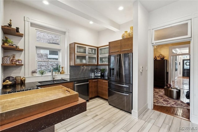 kitchen with appliances with stainless steel finishes, sink, backsplash, and beam ceiling