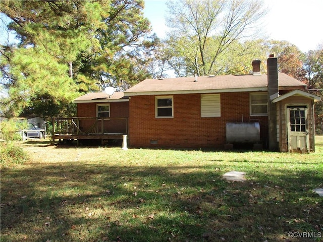 rear view of property featuring a wooden deck and a yard