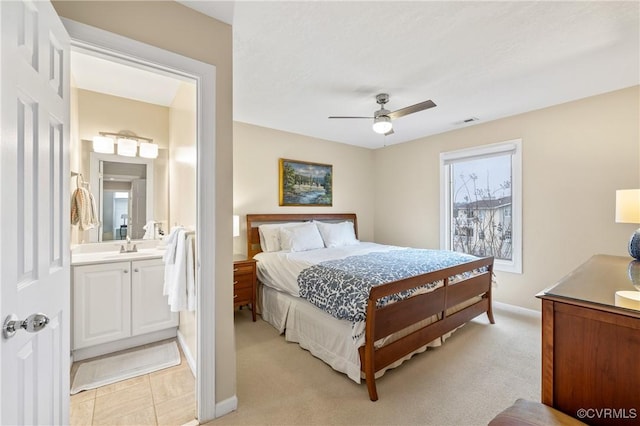 carpeted bedroom with ensuite bathroom, sink, and ceiling fan