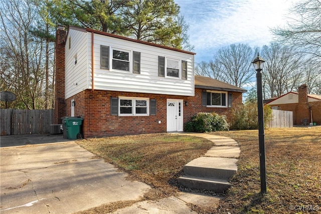 view of front of home featuring cooling unit and a front lawn