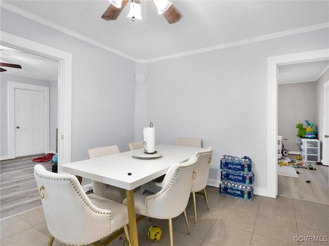 tiled dining room with ornamental molding and ceiling fan