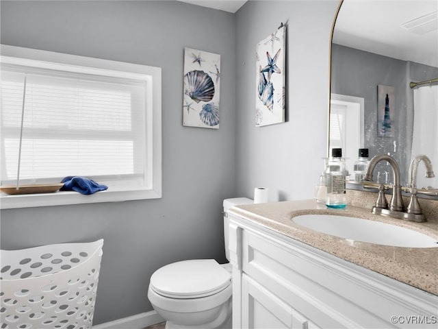 bathroom with plenty of natural light, toilet, curtained shower, and vanity