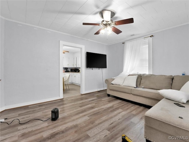 living room featuring crown molding, ceiling fan, and light hardwood / wood-style floors