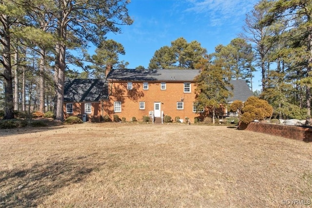 back of property featuring a lawn