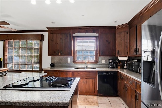 kitchen featuring sink, backsplash, light tile patterned flooring, ceiling fan, and black appliances