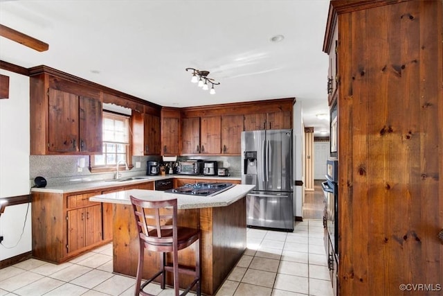 kitchen featuring appliances with stainless steel finishes, a breakfast bar, light tile patterned flooring, a kitchen island, and decorative backsplash