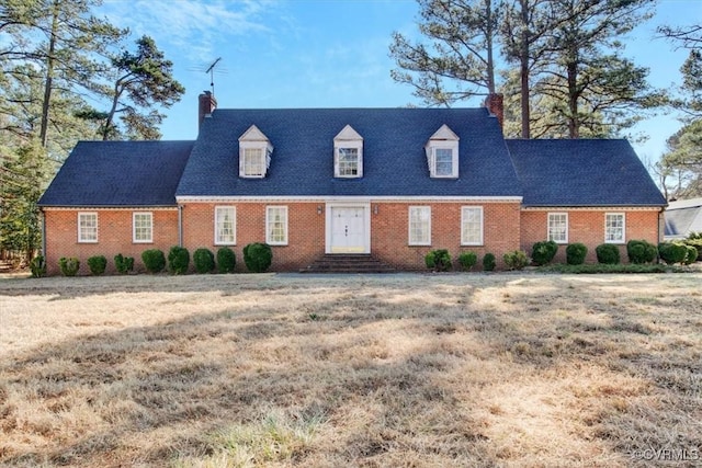 cape cod-style house with a front yard