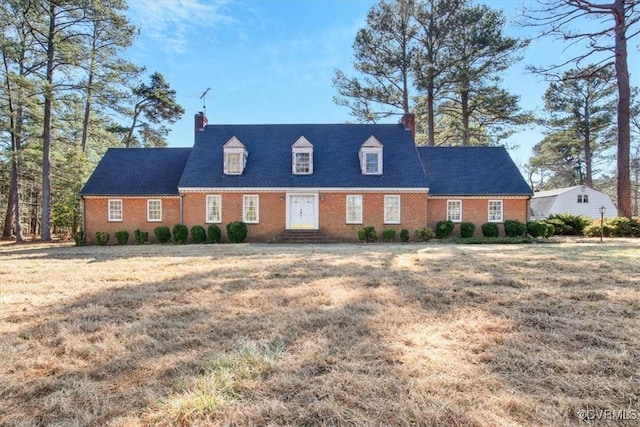 cape cod-style house featuring a front yard