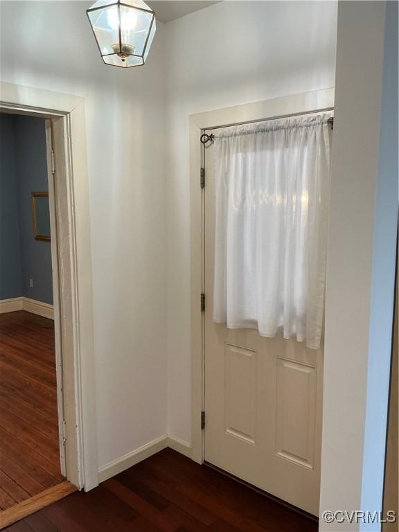 foyer entrance featuring dark wood finished floors and baseboards