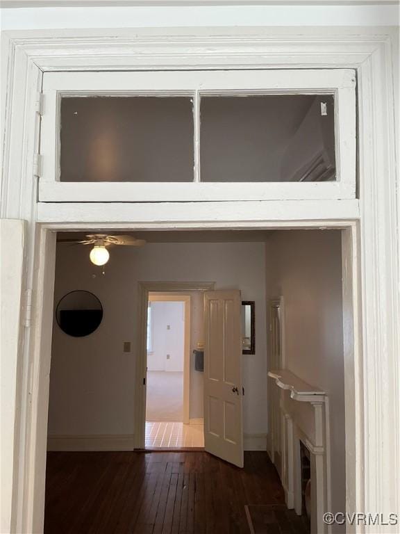 hallway with dark wood-type flooring and baseboards