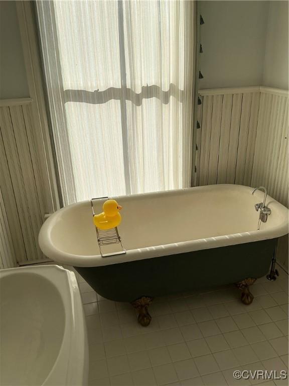 full bathroom with wainscoting and a freestanding tub