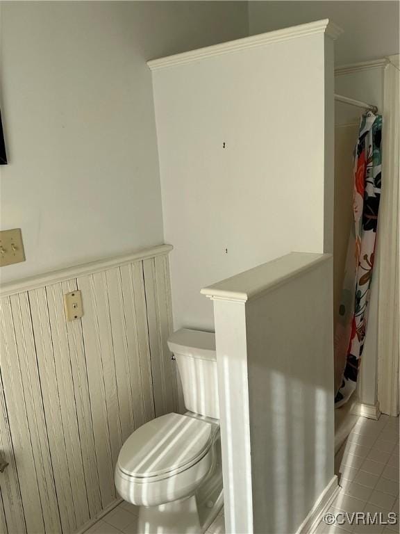 bathroom with tile patterned flooring, toilet, and a shower with shower curtain