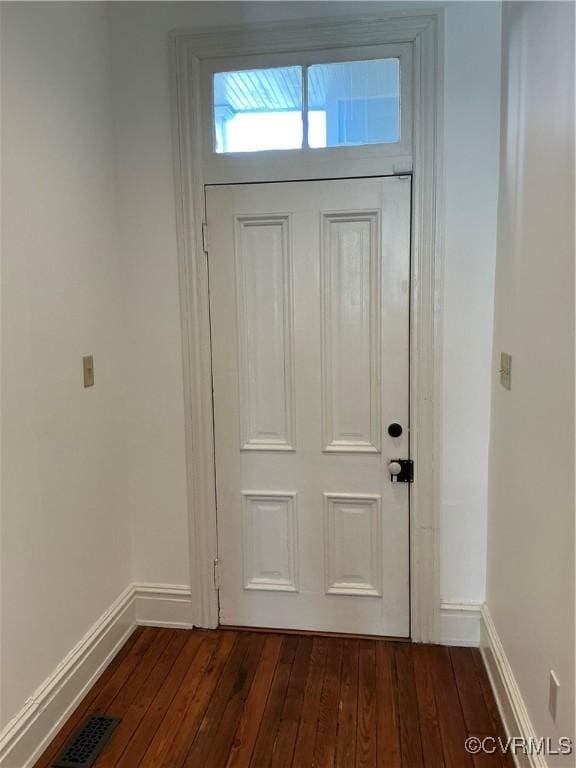 doorway to outside with dark wood-style floors, visible vents, and baseboards