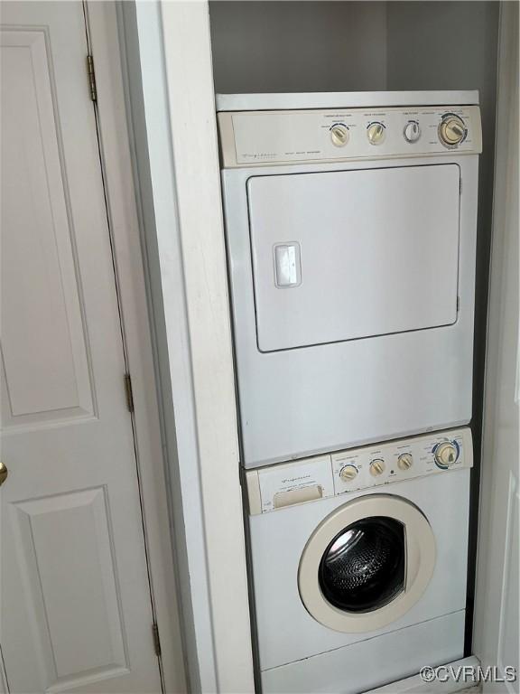 washroom featuring stacked washer / drying machine