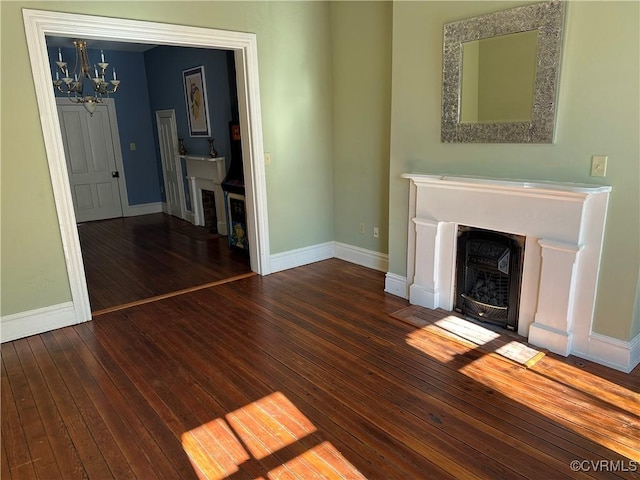 unfurnished living room featuring a notable chandelier, a fireplace with flush hearth, baseboards, and hardwood / wood-style floors