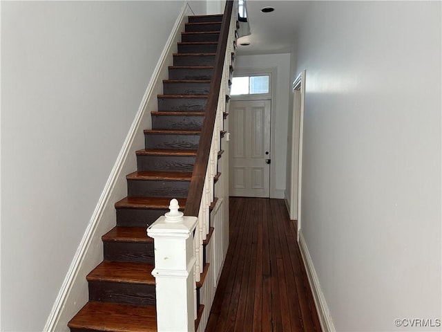 staircase featuring hardwood / wood-style flooring and baseboards