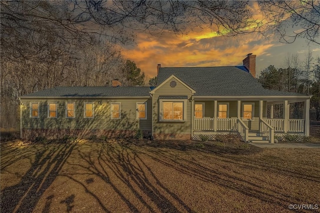 ranch-style home featuring a lawn and a porch