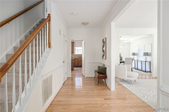 hall featuring ornamental molding and light wood-type flooring