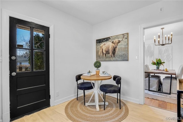 dining space featuring hardwood / wood-style flooring and a notable chandelier