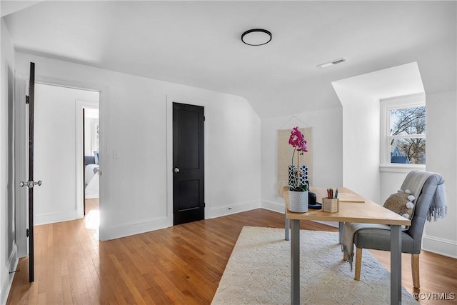 home office featuring lofted ceiling and wood-type flooring