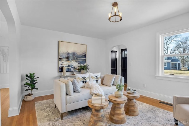 living room featuring a notable chandelier and light hardwood / wood-style floors