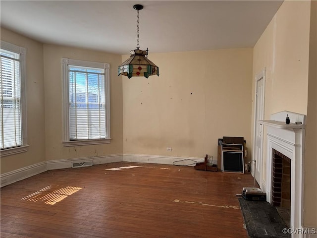 unfurnished dining area with a wealth of natural light, visible vents, and hardwood / wood-style floors