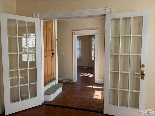 doorway to outside featuring visible vents, wood finished floors, and baseboards