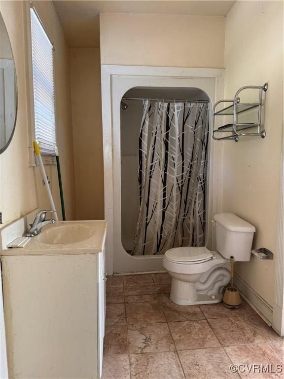 full bath featuring a shower with shower curtain, baseboards, toilet, and vanity