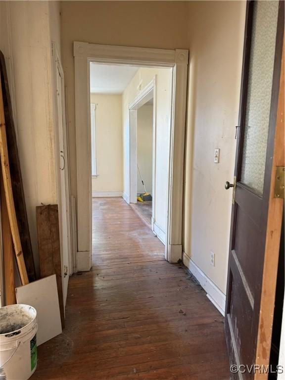 hall featuring baseboards and wood finished floors