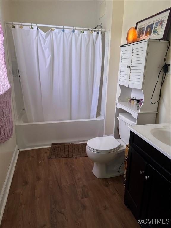 bathroom with vanity, shower / tub combo, toilet, and wood finished floors