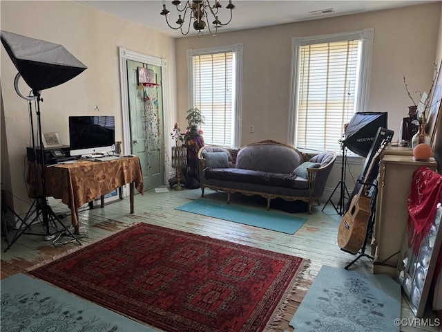 living area with a notable chandelier, wood finished floors, and visible vents