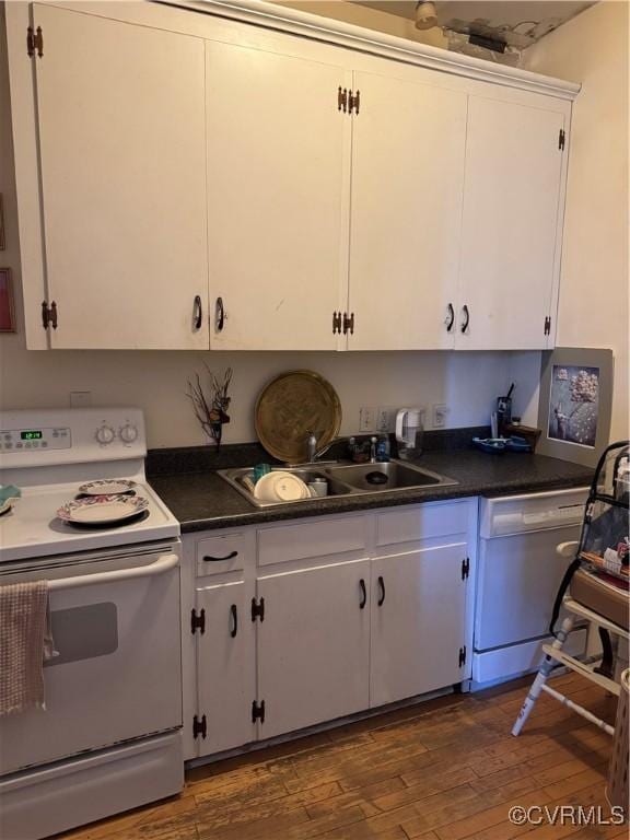 kitchen featuring a sink, white appliances, dark countertops, and dark wood-style flooring