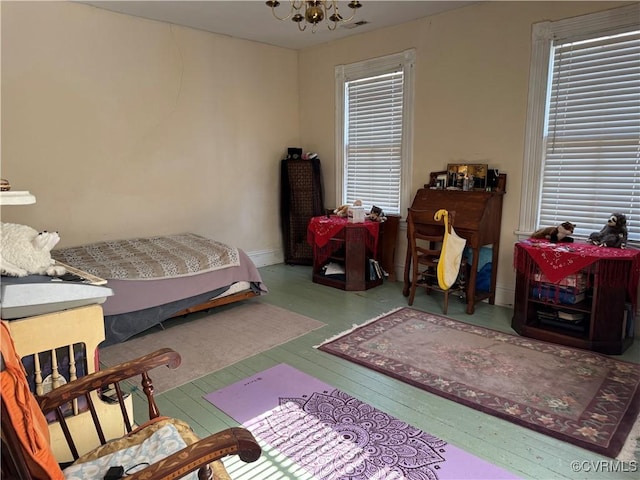 bedroom with hardwood / wood-style floors and an inviting chandelier