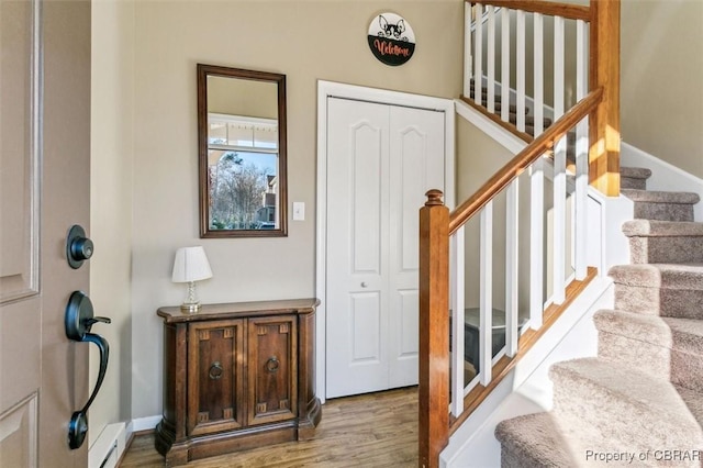 staircase featuring hardwood / wood-style flooring and baseboard heating