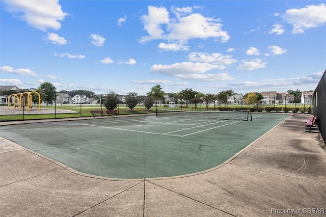 view of tennis court featuring a playground