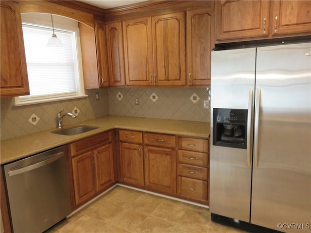 kitchen with stainless steel appliances, hanging light fixtures, sink, and decorative backsplash