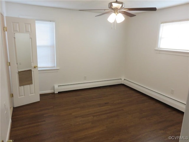 spare room featuring a baseboard heating unit, dark wood-type flooring, and ceiling fan