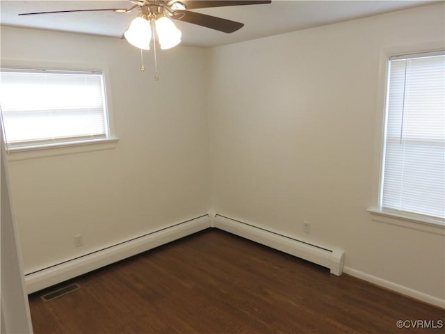 spare room featuring dark hardwood / wood-style flooring, a baseboard radiator, and ceiling fan