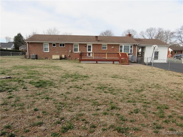 rear view of property with a yard, central air condition unit, and a deck