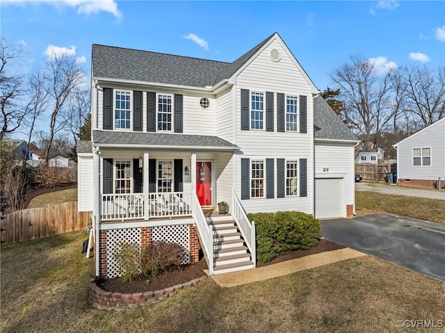 view of front facade featuring a garage, a front lawn, and covered porch