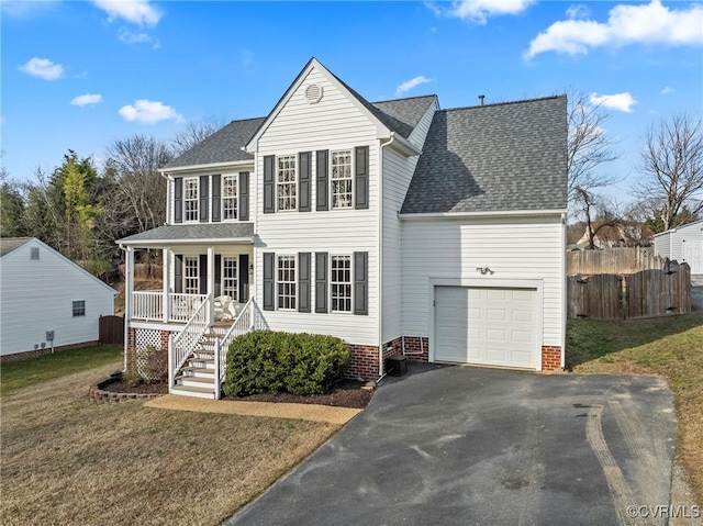 view of front of property featuring a garage, a front yard, and covered porch