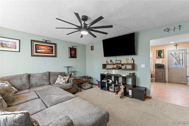 carpeted living room featuring ceiling fan and a textured ceiling